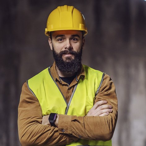 Ein Bauhelfer mit verschränkten Armen